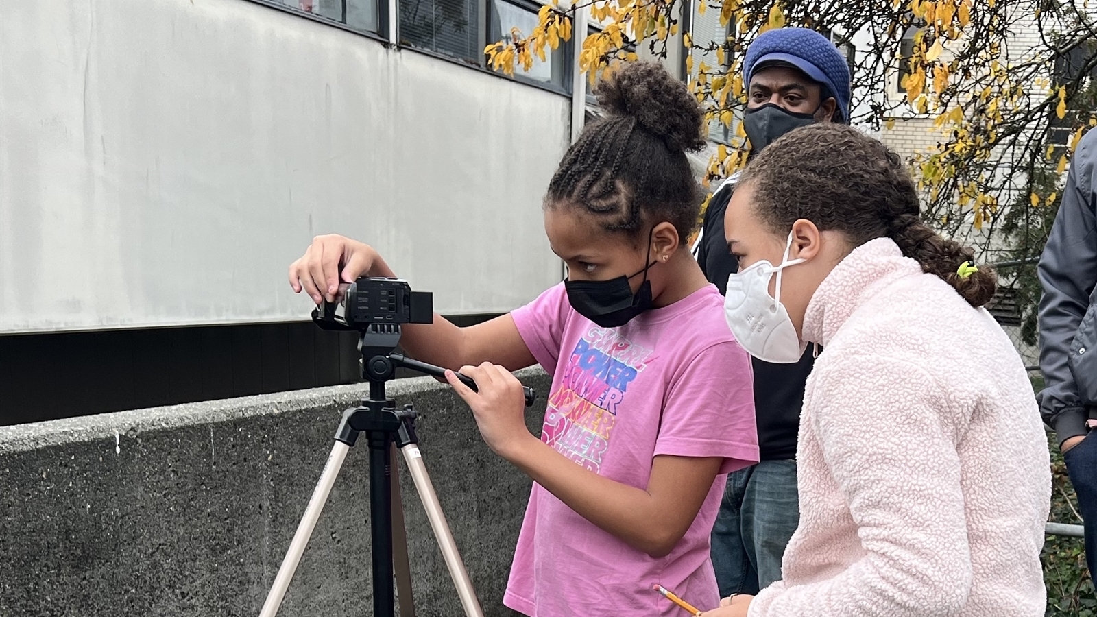 Kids filming outside at Langston with mentor