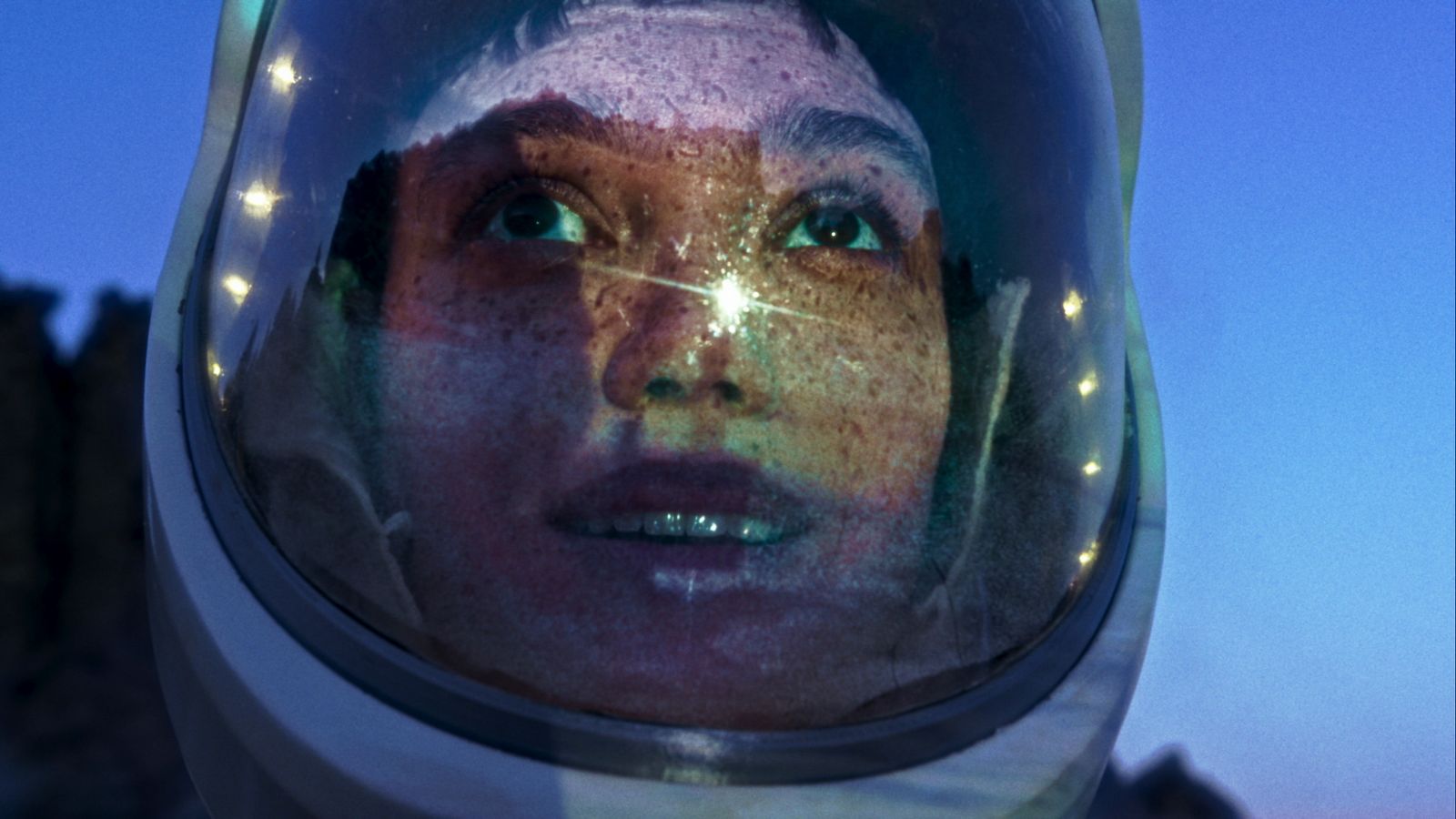 Astronaut on the ground looking up at a blue sky